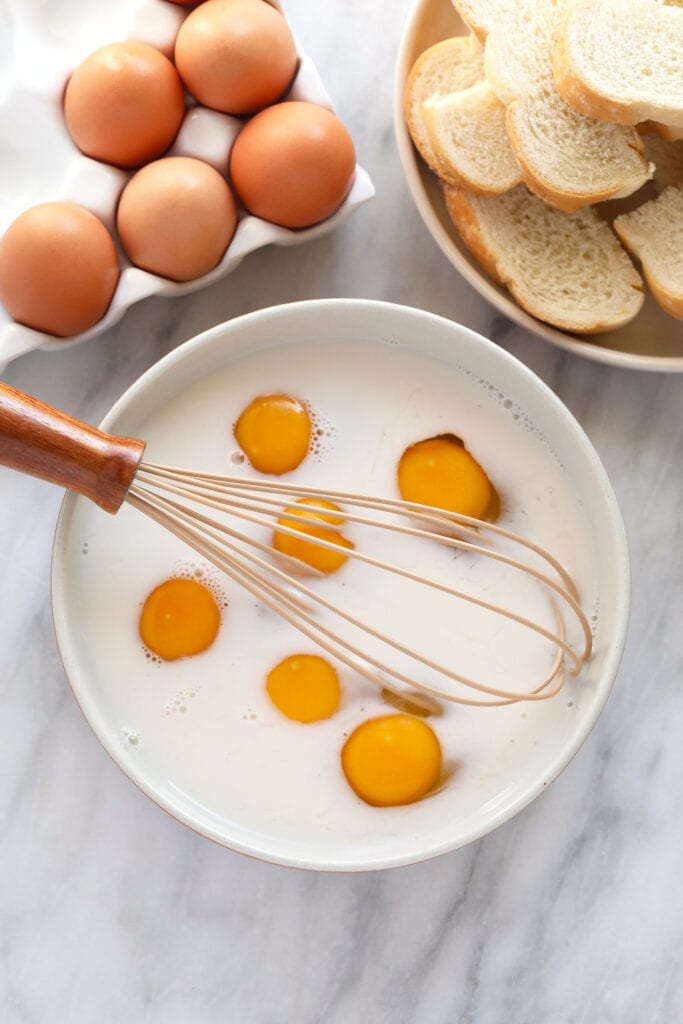 French Toast Sticks are an easy, kid-friendly breakfast recipe made with sliced brioche bread, egg, milk, and a cinnamon-sugar topping. egg and milk in a bowl with a whisk