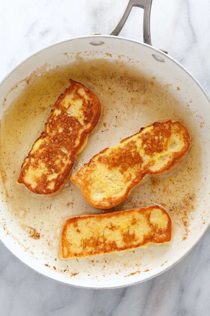 French Toast Sticks are an easy, kid-friendly breakfast recipe made with sliced brioche bread, egg, milk, and a cinnamon-sugar topping. cooking French toast sticks in pan