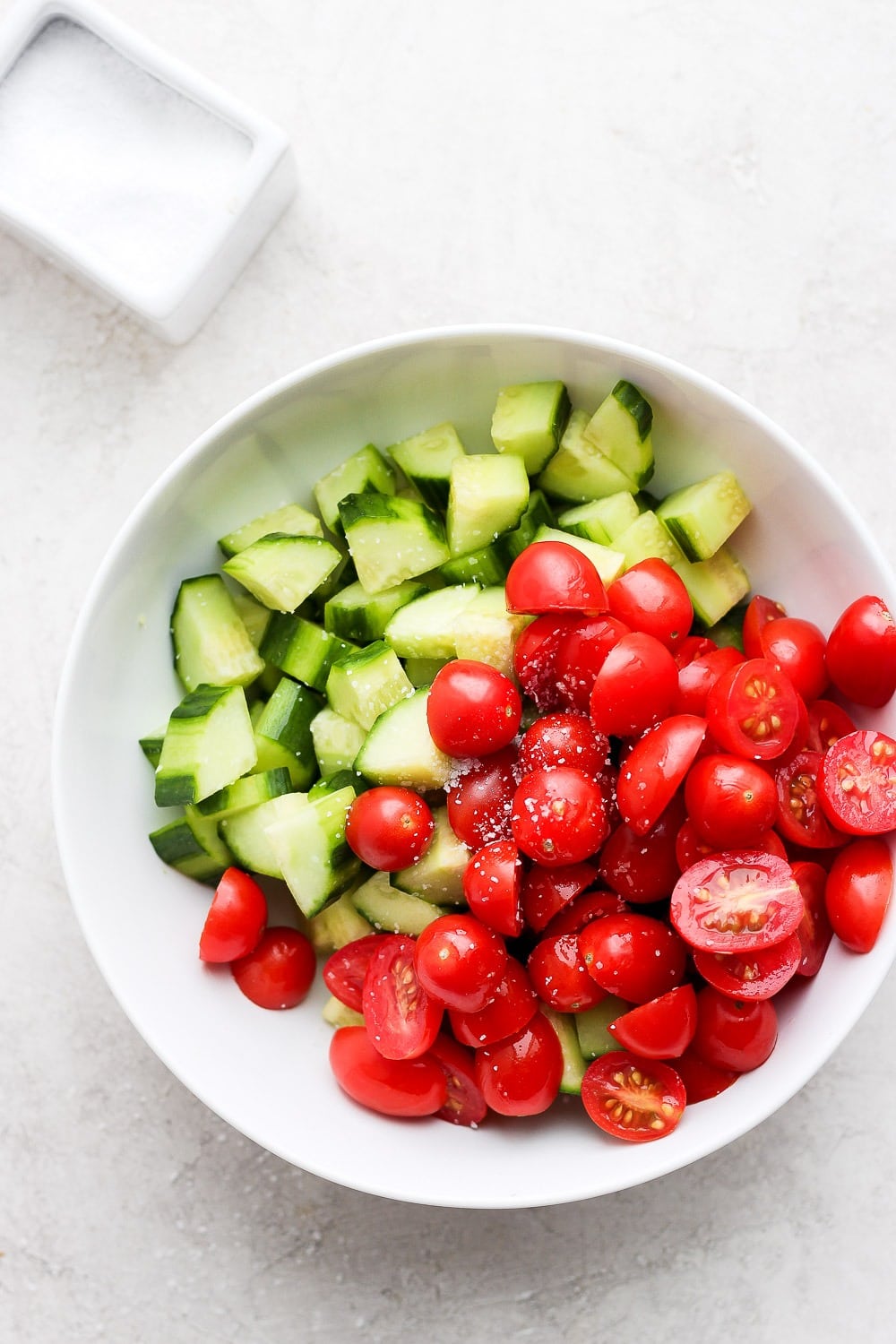 This Greek salad is made with sweet cherry tomatoes, cucumber, red onion, feta, and homemade Greek salad dressing! It is perfect for meal prep, a summer picnic, or just a healthy summer meal! Cucumbers and Tomatoes