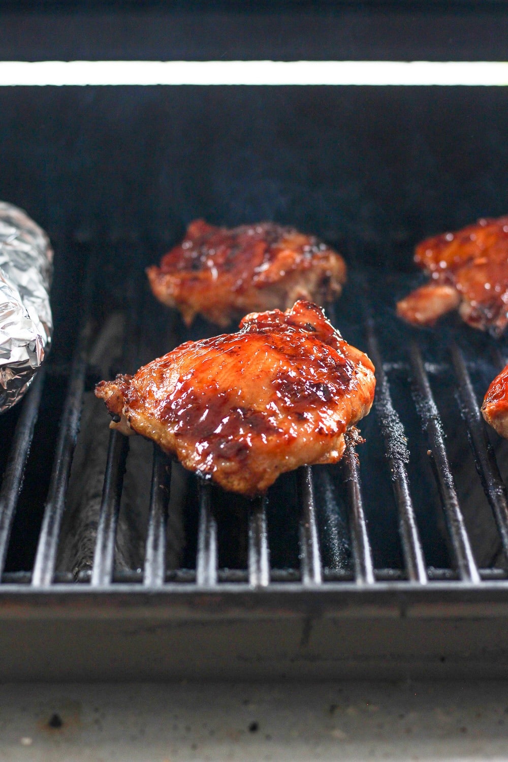 Incredibly juicy grilled bbq chicken thighs made with a dry rub and your favorite bbq sauce! chicken thighs on grill