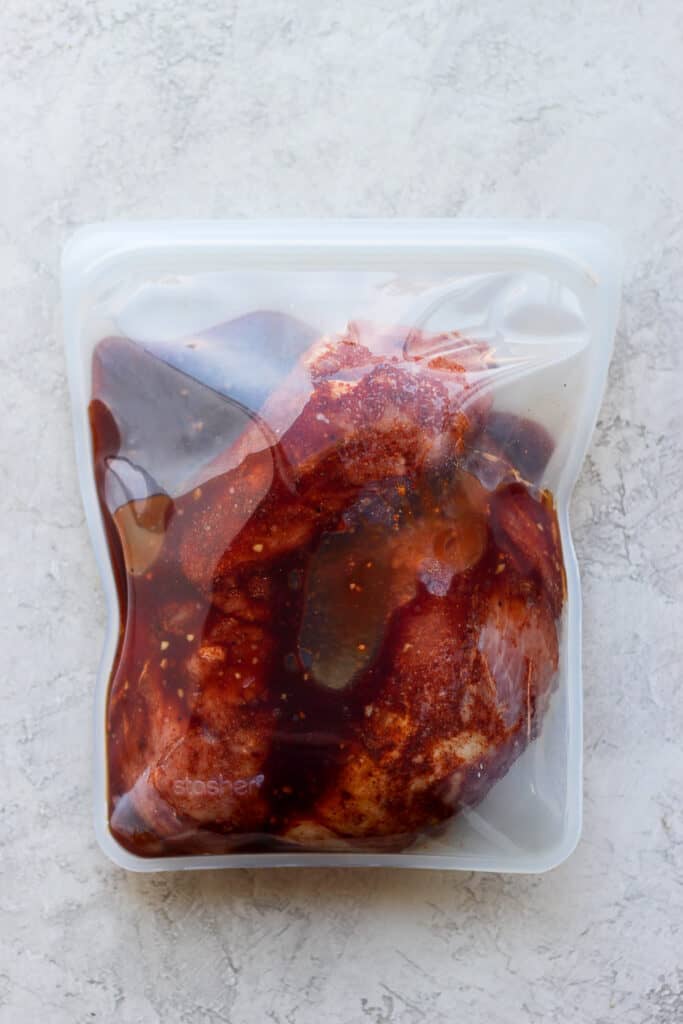 The easiest, most flavorful pork tenderloin marinade you'll ever try. This pork tenderloin marinade recipe is sweet and salty made with BBQ sauce, soy sauce, and garlic. pork tenderloin marinating in a Stasher bag