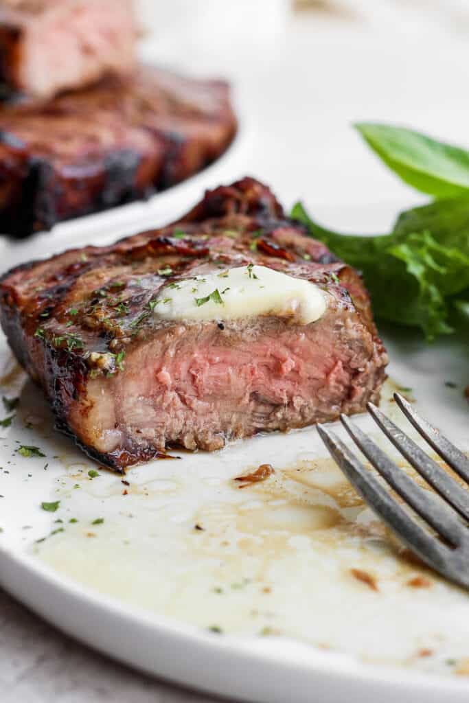 Grilling steak may seem intimidating, but in this post, we'll teach you how to grill steak and make it perfectly juicy on the inside with a beautifully charred crust on the outside every time. steak sliced into with butter