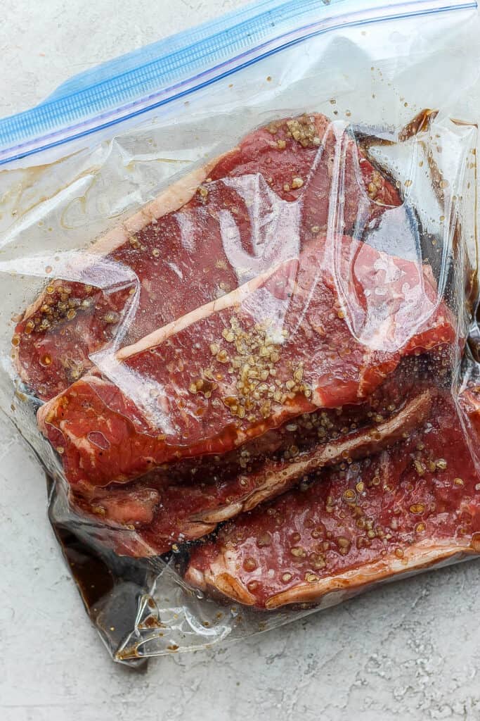 Get tender, juicy, perfectly grilled steak with this "how to grill steak" post. We'll give you the best tips and tricks for grilling steak like a professional. steaks marinating in pastic bag