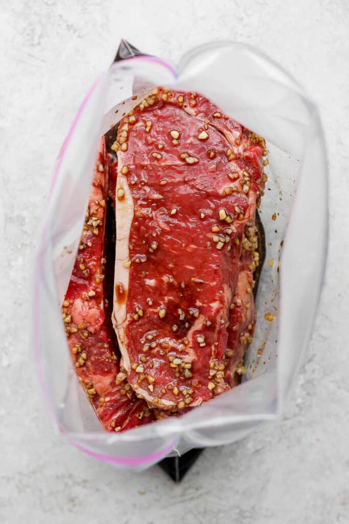 steaks marinating in plastic bag