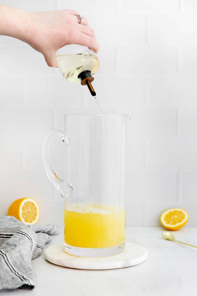 Pouring simple syrup into a pitcher.