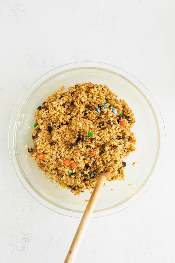 These flourless monster cookie bars are packed with oats, all-natural peanut butter, m&ms and chocolate chips, making them the perfect sweet treat. Enjoy! monster bars cookie dough in large bowl