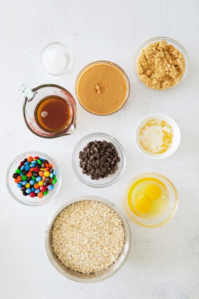 These flourless monster cookie bars are packed with oats, all-natural peanut butter, m&ms and chocolate chips, making them the perfect sweet treat. Enjoy! monster cookie bars ingredients on countertop