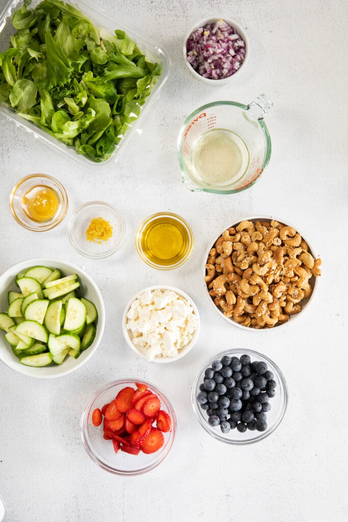 All of the ingredients for a spring mix salad in small bowls.