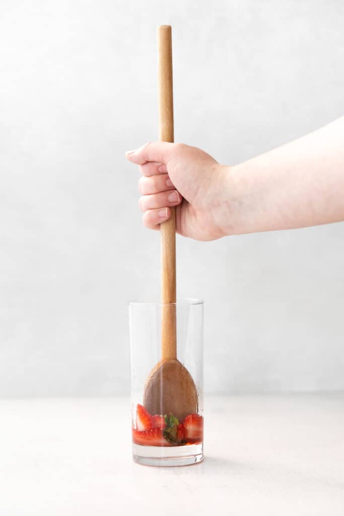 Fancy up your rum cocktail recipes with this strawberry mojito recipe! It's made with strawberries, mint, white rum, club soda, and a homemade mint simple syrup. mudling strawberries