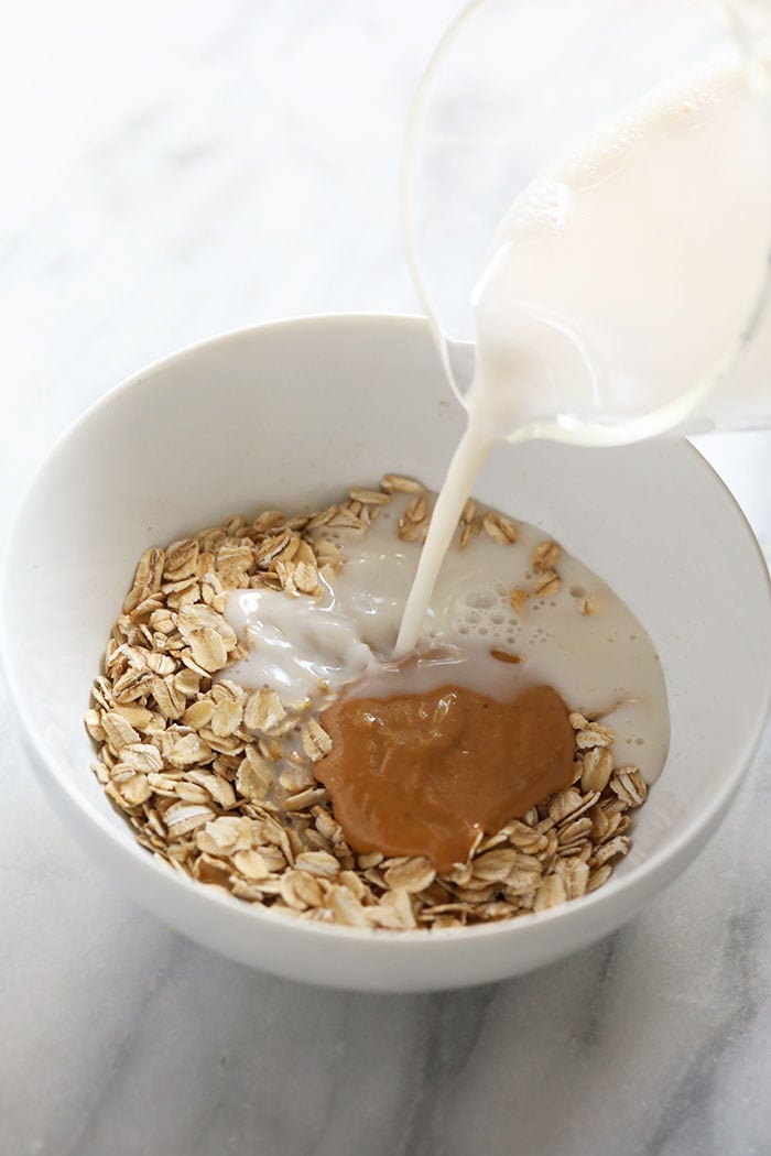 Got 2 minutes? Then, you have time for a healthy breakfast! Make our 2-Minute Microwave Oatmeal. This recipe tastes exactly like chocolate chip cookie dough AND it's healthy. adding milk to oatmeal in bowl