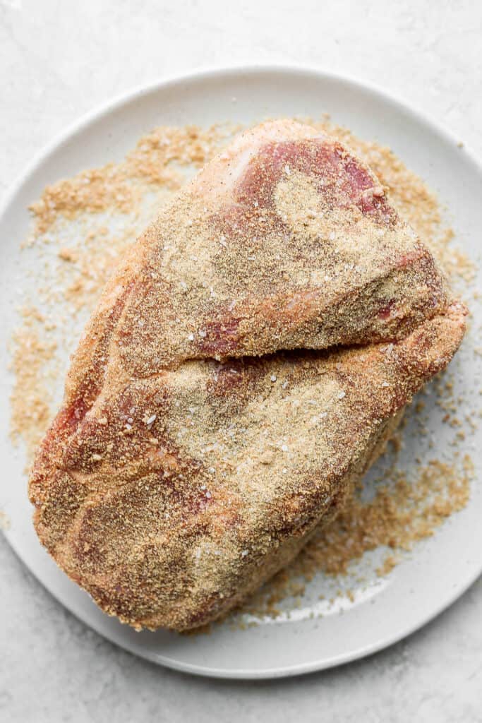 The best pork shoulder recipes are cooked low and slow. This slow roasted pork shoulder is slightly sweet and incredibly tender with crispy, crunchy edges. This is one of the best pork shoulder recipes of all time! seasoned pork on plate