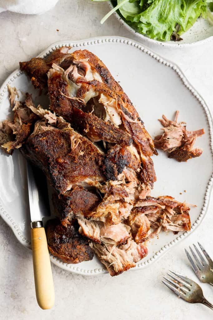 The best pork shoulder recipes are cooked low and slow. This slow roasted pork shoulder is slightly sweet and incredibly tender with crispy, crunchy edges. This is one of the best pork shoulder recipes of all time! pork shoulder on plate shredded