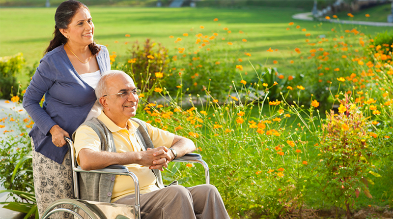 Women pushing man in wheel chair