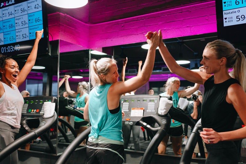 People cheering on workout equipment.