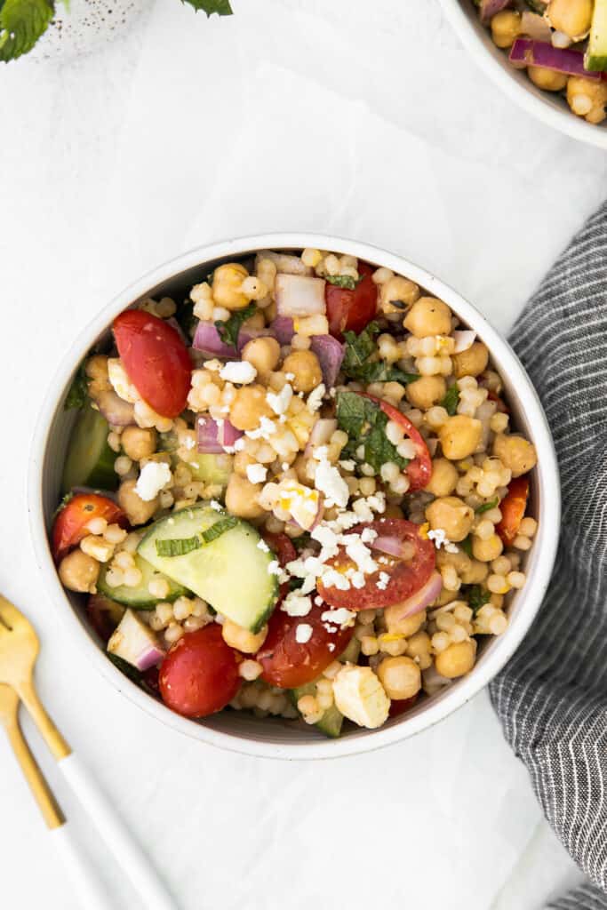 This Mediterranean couscous salad is the perfect addition to any summer meal. Serve this veggie-packed salad as a delicious side dish or a colorful main dish. Enjoy! individual serving of mediterranean couscous salad in a bowl