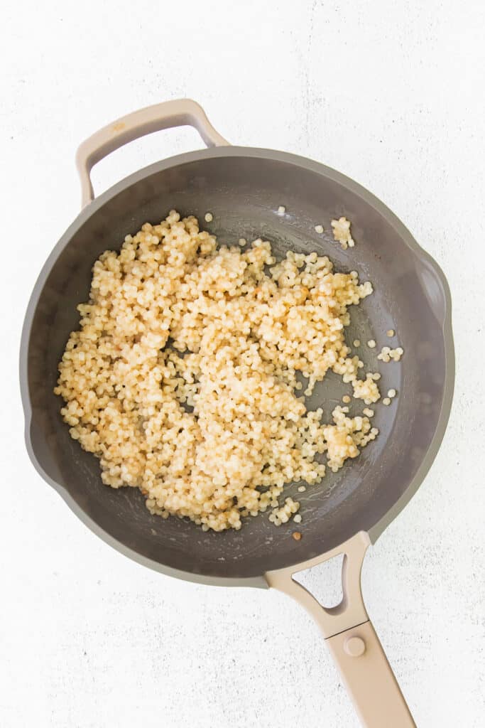 This Mediterranean couscous salad is the perfect addition to any summer meal. Serve this veggie-packed salad as a delicious side dish or a colorful main dish. Enjoy! israeli couscous in a pan