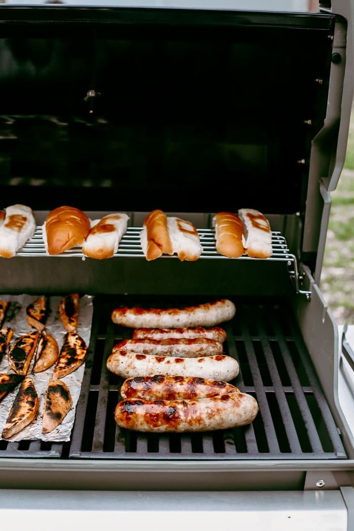 Ever heard of beer brats? Beer boiled brats are by far the most delicious way to cook brats. Start by boiling your brats in beer and then finish them off with a sear on the grill, some ketchup & mustard, and relish too! brats and buns on grill