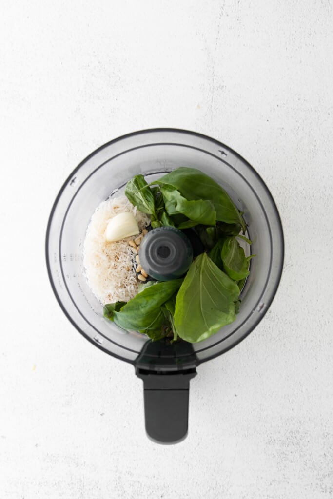 This basil pesto comes together in less than 5 minutes. It's made with fresh basil, garlic cloves, olive oil, parmesan cheese, and pine nuts. basil in food processor