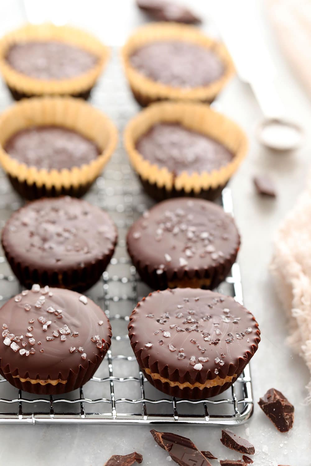 Homemade almond butter cups are a simple dessert that will satisfy your sweet tooth craving! Plus, these almond butter cups are topped with flakey sea salt. almond butter cups on metal rack