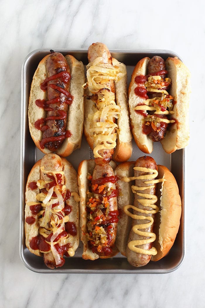 Ever heard of beer brats? Beer boiled brats are by far the most delicious way to cook brats. Start by boiling your brats in beer and then finish them off with a sear on the grill, some ketchup & mustard, and relish too! beer brats on baking sheet