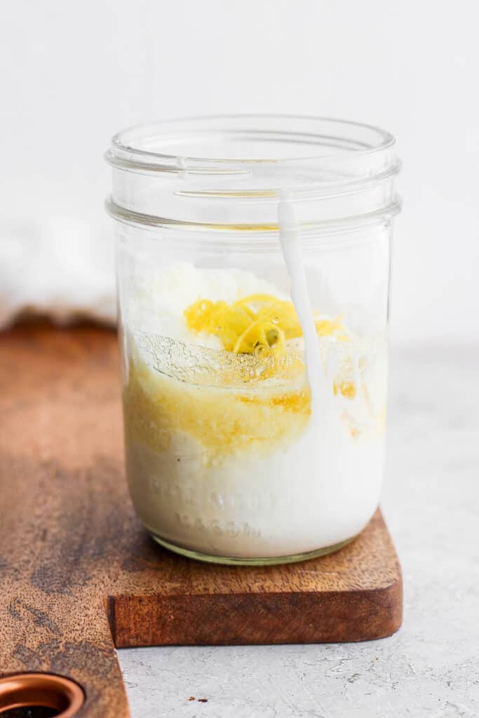 All the ingredients for caesar dressing in a mason jar.