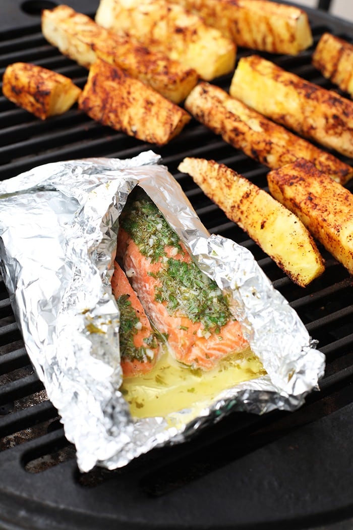 This grilled salmon in foil with pineapple needs to be the star of your next summer bbq. This healthy meal is made in under 30 minutes on the grill and full of fresh flavor! Salmon in a foil on the grill with pineapple next to it