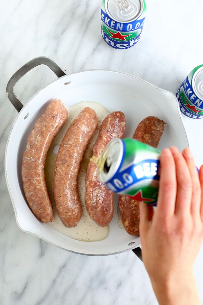 Ever heard of beer brats? Beer boiled brats are by far the most delicious way to cook brats. Start by boiling your brats in beer and then finish them off with a sear on the grill, some ketchup & mustard, and relish too! uncooked brats in pan