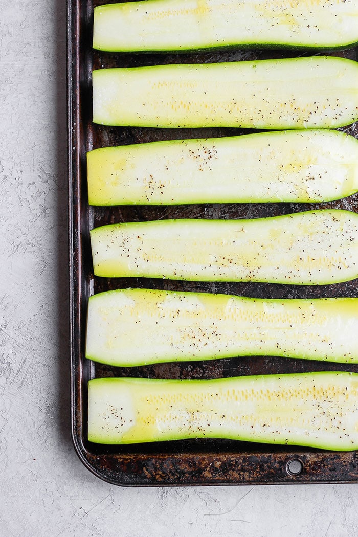 Turn on the grill and throw on some zucchini! Making grilled zucchini is easy and if you do it right you'll end up with grilled zucchini with a little crunch rather than a soggy mess. Grab the zucchini from your garden or the grocery store and get grilling! fresh zucchini on a baking sheet drizzled in oil