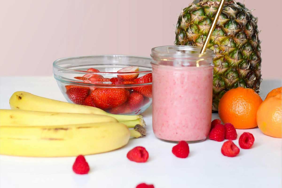 Smoothie and fruit sitting on a counter