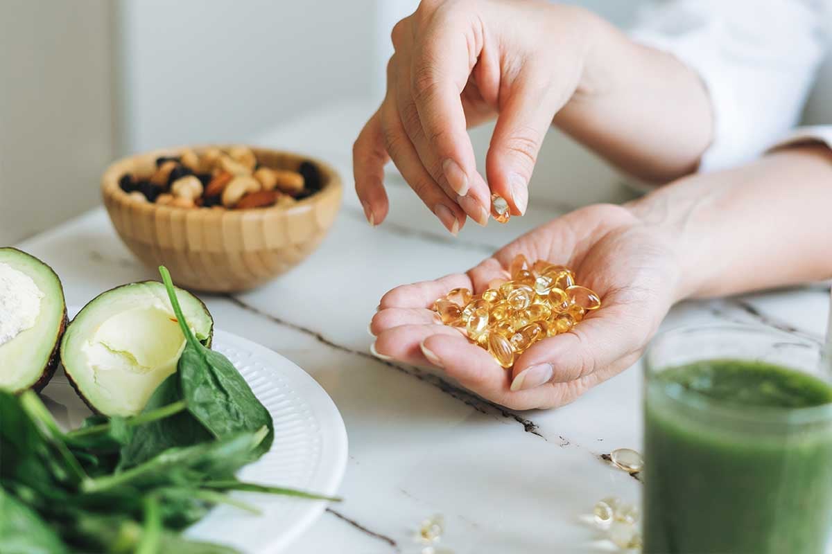 Woman holding supplements near food
