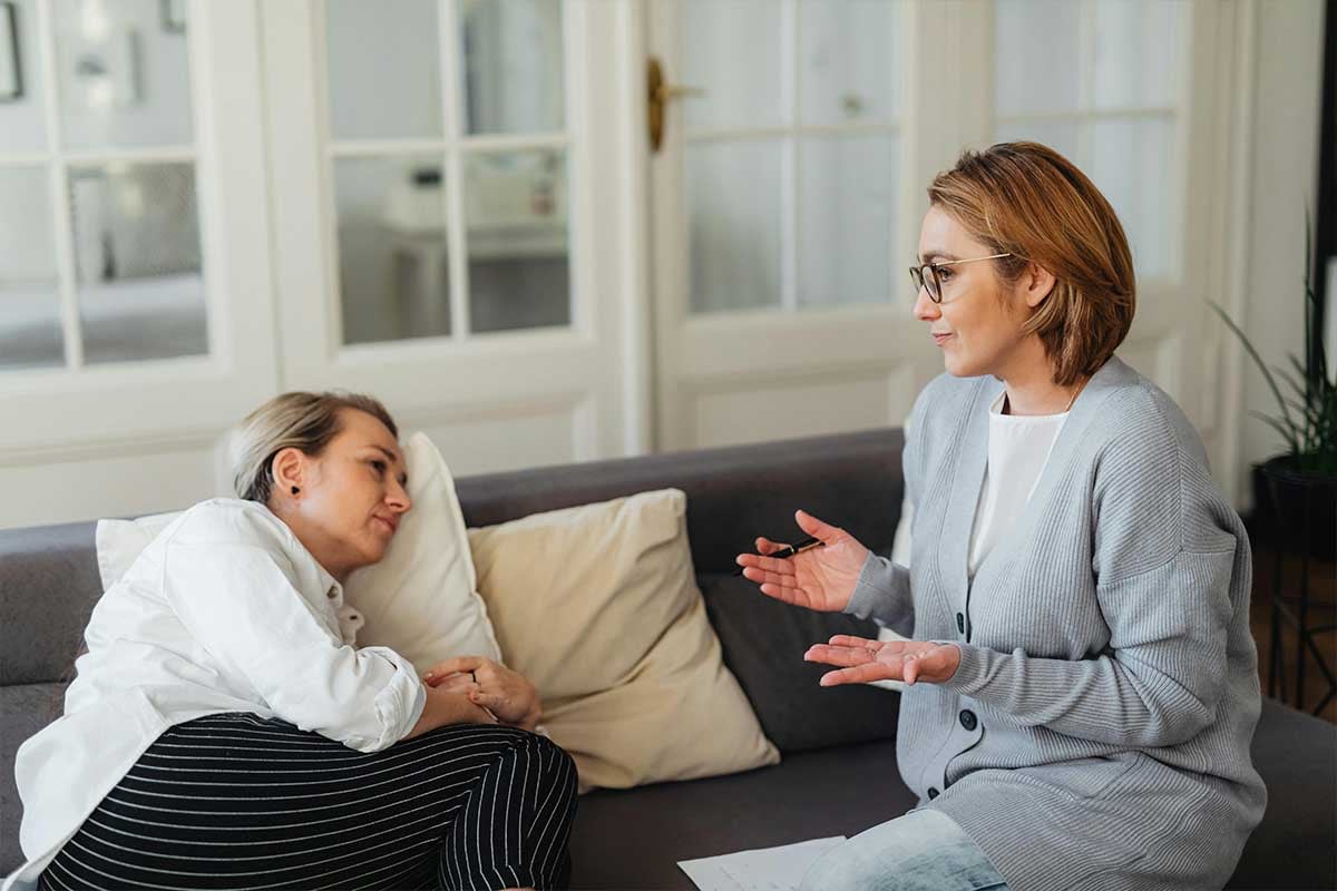Woman laying on a couch talking with a friend