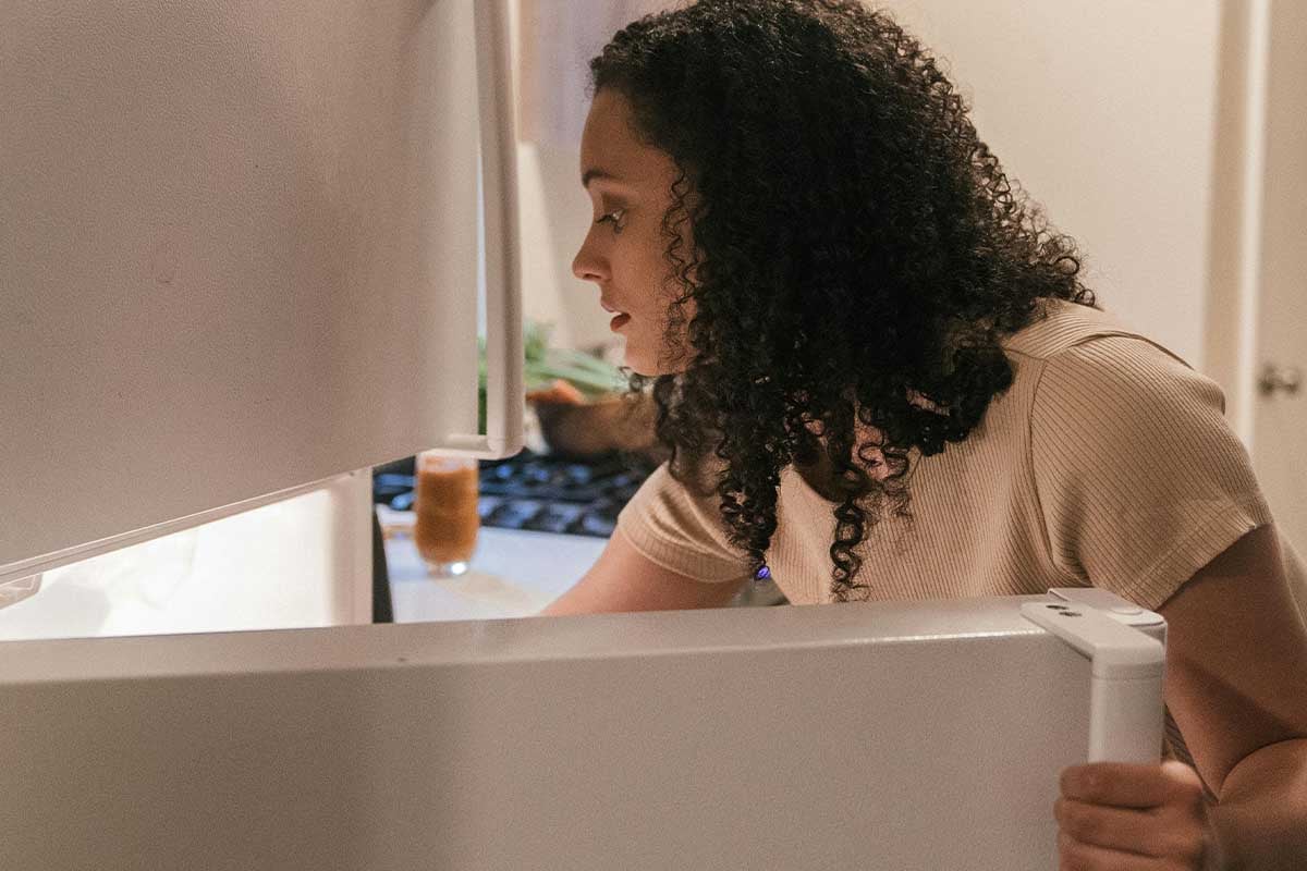 Woman opening fridge